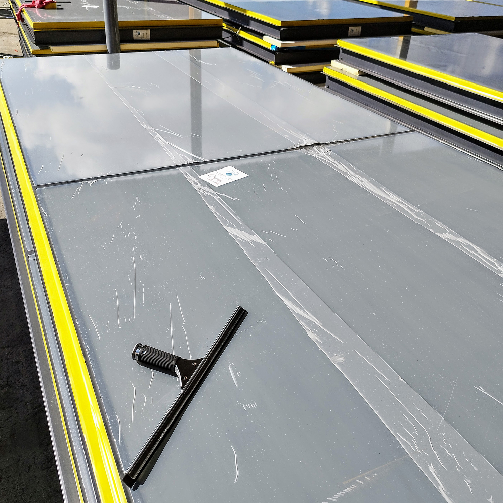 Technician applying Premium Blue Protective Tape to an aluminium window frame.